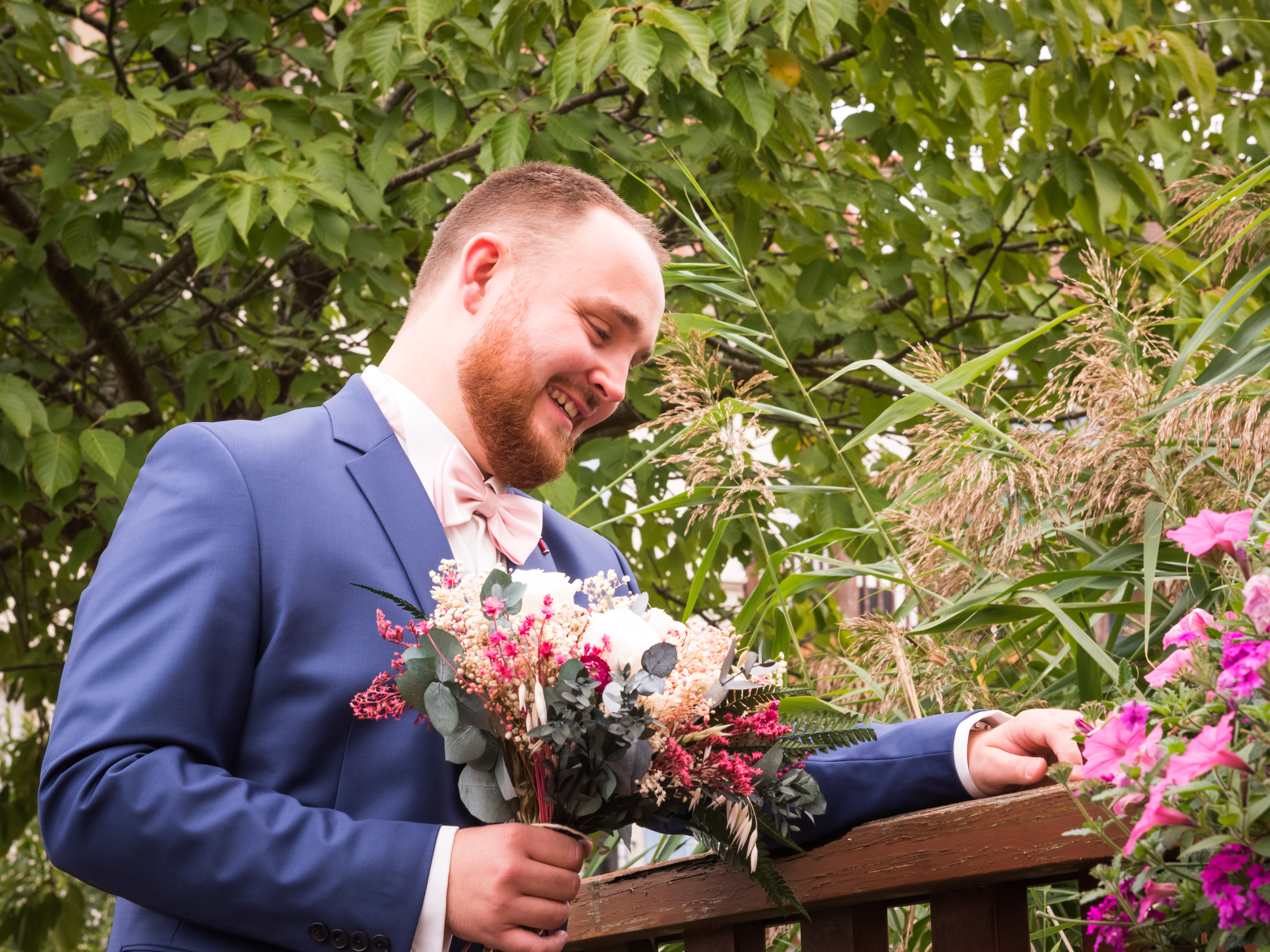 Mariage de Laurie et Valentin first look, le marié attend la mariée en tenant son bouquet de fleurs séchées